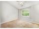 Neutral bedroom with a ceiling fan, natural light, and plush carpet, creating a relaxing atmosphere at 10223 Reindeer Way Ln, Charlotte, NC 28216