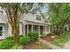 Inviting townhome with lush landscaping, a brick facade, and a charming covered front porch at 10223 Reindeer Way Ln, Charlotte, NC 28216