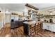 Modern kitchen with island and seating, stainless steel appliances, pot rack, and wood flooring at 110 Heritage Dr, Kings Mountain, NC 28086