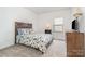 Comfortable bedroom with a floral-patterned comforter, soft carpeting, and a natural light window at 11116 Godwit Ln, Charlotte, NC 28278