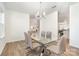 Dining room with wood floors, modern chandelier, and a glass table with seating for six at 11116 Godwit Ln, Charlotte, NC 28278