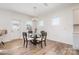 Bright dining room featuring modern chandelier, wood floors, and a round glass table with seating for four at 11116 Godwit Ln, Charlotte, NC 28278