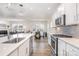Well-lit kitchen with quartz countertops, stainless steel appliances, white cabinets, and an island with sink and dishwasher at 11116 Godwit Ln, Charlotte, NC 28278