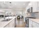 Well-lit kitchen with quartz countertops, stainless steel appliances, white cabinets, and an island with sink and dishwasher at 11116 Godwit Ln, Charlotte, NC 28278