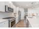 Beautiful kitchen featuring white cabinets, stainless steel appliances, quartz countertops, and wood floors at 11116 Godwit Ln, Charlotte, NC 28278