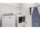 Convenient laundry room with modern appliances, shelving, and space for ironing at 11116 Godwit Ln, Charlotte, NC 28278