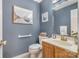 Traditional powder room with blue walls and framed artwork above toilet with wooden vanity at 127 Fantasy Ln, Mooresville, NC 28117