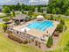 Aerial view of a community pool with a sundeck, lounge chairs, and tables with umbrellas at 129 Hawks Creek Pkwy, Fort Mill, SC 29708