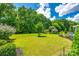 Lush backyard featuring a large lawn, mature trees, and a landscaped perimeter at 129 Hawks Creek Pkwy, Fort Mill, SC 29708