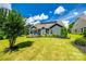 Large backyard with a well-maintained lawn, mature trees, and solar panels on the roof at 129 Hawks Creek Pkwy, Fort Mill, SC 29708