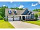 Attractive exterior view showcasing a well-maintained home with a two-car garage and beautifully landscaped front yard at 129 Hawks Creek Pkwy, Fort Mill, SC 29708