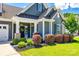 Inviting front porch adorned with hanging floral baskets and meticulously maintained landscaping at 129 Hawks Creek Pkwy, Fort Mill, SC 29708