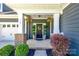 Close up view of the front porch with hanging floral arrangements and well-manicured greenery at 129 Hawks Creek Pkwy, Fort Mill, SC 29708