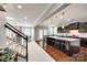 Open floor plan from stairs to kitchen with a large island, dark cabinets, and stainless steel appliances at 129 Hawks Creek Pkwy, Fort Mill, SC 29708