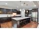 This kitchen is equipped with an island, granite countertops, stainless steel appliances, and dark cabinets at 129 Hawks Creek Pkwy, Fort Mill, SC 29708