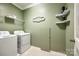 This laundry room offers shelving, modern appliances, and a practical layout for efficient chore management at 129 Hawks Creek Pkwy, Fort Mill, SC 29708