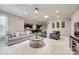 Comfortable living room with grey sofas and chairs, an open floor plan, and views into the kitchen at 129 Hawks Creek Pkwy, Fort Mill, SC 29708