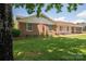 View of the charming brick home featuring a well-manicured lawn and lush, mature trees at 1613 Spangler Dr, Shelby, NC 28150
