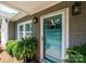 Close-up of the teal front door framed by decorative plants and classic wall lanterns at 2024 5Th Street Nw Pl, Hickory, NC 28601
