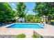 Large in-ground pool with a patio, surrounded by lush greenery and fenced for added privacy and security at 2024 5Th Street Nw Pl, Hickory, NC 28601