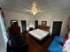 This bedroom features hardwood floors, a unique ceiling, and simple furniture at 208 S Ransom St, Gastonia, NC 28052