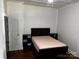 Bedroom with a bed, built-in storage, wood floors and white paneled walls at 208 S Ransom St, Gastonia, NC 28052
