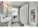 Bathroom featuring white tile, vanity, and shower with decorative shelves for storage at 2111 Parkdale Ave, Gastonia, NC 28052
