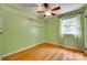 Bedroom featuring hardwood floors, a ceiling fan, and a window with green walls at 2111 Parkdale Ave, Gastonia, NC 28052