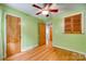 Bright bedroom featuring hardwood floors, a ceiling fan, and a window with green walls at 2111 Parkdale Ave, Gastonia, NC 28052