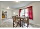 Bright dining room with hardwood floors, neutral wall paneling, and a view into the adjacent kitchen area at 2111 Parkdale Ave, Gastonia, NC 28052
