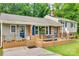 A cozy split-level home featuring brick accents, blue shutters, an inviting deck, and outdoor seating arrangements at 2111 Parkdale Ave, Gastonia, NC 28052