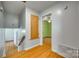 Hallway with hardwood floors leading to a bedroom, featuring a closet and a stairwell at 2111 Parkdale Ave, Gastonia, NC 28052