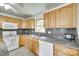 A well-lit kitchen with light wood cabinets, granite countertops, and modern appliances offer a functional cooking space at 2111 Parkdale Ave, Gastonia, NC 28052