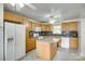 A bright kitchen features light wood cabinets, a granite island, and modern appliances for convenient cooking at 2111 Parkdale Ave, Gastonia, NC 28052