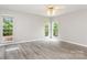 Bright bedroom with wood floors, white walls, two windows, and a ceiling fan at 270 Kilmer Ln, Mooresville, NC 28115