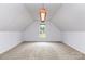 Bright bonus room with dormer window, neutral carpeting, and a modern light fixture, offering versatility at 270 Kilmer Ln, Mooresville, NC 28115