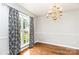 Dining room with hardwood floors, decorative chandelier, and large window with patterned drapes at 270 Kilmer Ln, Mooresville, NC 28115