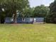 A manufactured home with a blue exterior and a grassy front yard at 41042 Dennis Rd, Albemarle, NC 28001