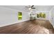 Spacious living room featuring wood floors, ceiling fan, and natural light from the windows at 41042 Dennis Rd, Albemarle, NC 28001