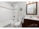 Bathroom features a shower-tub combo with white tile surround and updated vanity at 4200 Tyndale Ave, Charlotte, NC 28210