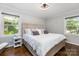 Bright bedroom with a king bed, hardwood floors, ceiling fan, and two windows at 4200 Tyndale Ave, Charlotte, NC 28210