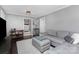 Cozy living room with gray paneled walls, plush gray sofa, and dark hardwood floors at 4200 Tyndale Ave, Charlotte, NC 28210