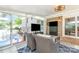 Beautiful sunroom with tile floor, brick accent wall, flat screen tv and sliding glass door to outdoor pool at 4200 Tyndale Ave, Charlotte, NC 28210