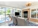 The sunroom features a brick wall, two televisions, and wicker furniture with views of the backyard pool at 4200 Tyndale Ave, Charlotte, NC 28210