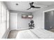 Bedroom with two mounted televisions, a gaming chair, a ceiling fan, and a white door at 4313 Gibbon Crossing Dr, Charlotte, NC 28269