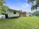 A large backyard features a house with light yellow siding and a lush green lawn at 46 Donna Dale Se Ave, Concord, NC 28025