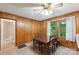 Adjacent dining area with wood paneling, ceiling fan, and a view of the backyard at 46 Donna Dale Se Ave, Concord, NC 28025