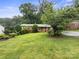 Charming single-story home featuring a brick facade, lush green lawn, and mature trees at 46 Donna Dale Se Ave, Concord, NC 28025