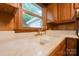 Close-up of the kitchen sink featuring laminate countertops, wood cabinetry, and a window at 46 Donna Dale Se Ave, Concord, NC 28025