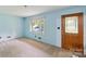Bright living room with neutral carpet, light blue walls and a decorative wooden front door at 46 Donna Dale Se Ave, Concord, NC 28025